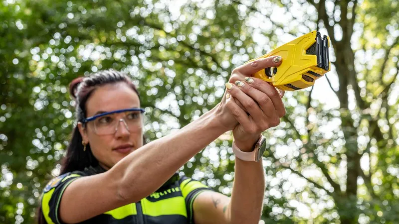 Politievrouw met taser in de hand
